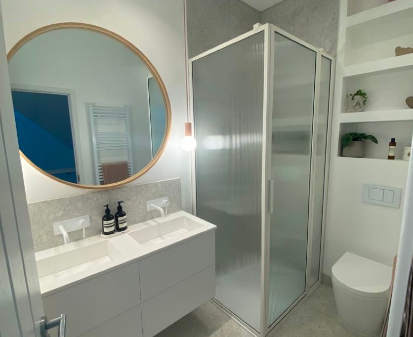 Photo of a sink, large mirror, shower, and toilet in a modern bathroom that's been fitted in Southampton.
