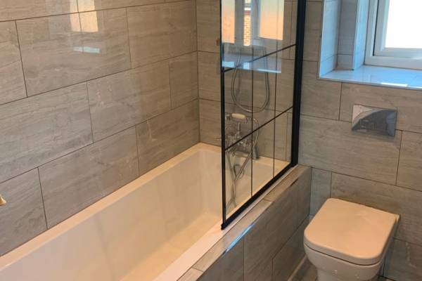 Photo of a new, white, modern bath and toilet that's been fitted in Southampton.